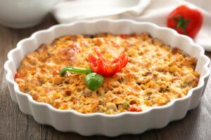 Baking dish with delicious turkey casserole on table, closeup