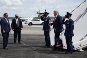 El presidente Donald Trump saluda al gobernador de Florida Ron DeSantis al llegar al aeropuerto de Fort Myers, Florida, el 16 de octubre de 2020.
