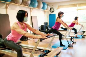 group of mature women doing excercise, Pilates and Yoga with social distancing and face mask