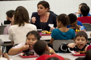 La reconocida chef Rachael Ray come con niños en una escuela pública para promover alimentos saludables.