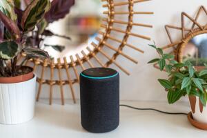 Amazon Alexa Echo Plus on a white table with green plants in the background