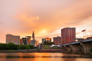 The skyline of Hartford, Connecticut at sunset. Photo shows Founders Bridge and Connecticut River. Hartford is the capital of Connecticut. 