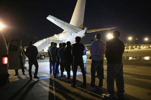 Inmigrantes indocumentados esperan para subirse a un avión de ICE.