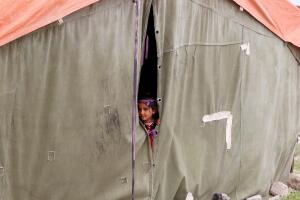 A displaced Iraqi girl who fled her home with her family poses at her family's tent outside of Hammam al-Alil camp south of Mosul