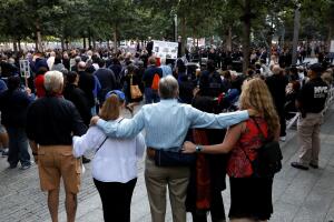 People embrace as they gather at the National 911 Memorial and Museum during ceremonies marking the 16th anniversary of the September 11, 2001 attacks in New York