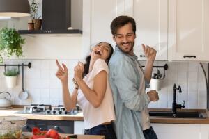 Casal feliz dançando na cozinha