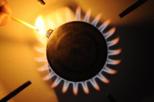 A man lights a match on the flame of a g