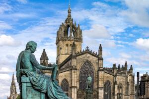 Great Britain. Scotland. Edinburgh. The Royal Mile. The St Giles Cathedral And. in The Foreground The Monument To The Philosopher David Hume.