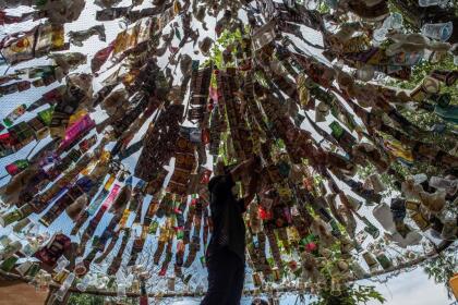 An Indonesian activist from ECOTON (ecological observation and wetland conservation) prepares an installation made with used plastic, including 4,444 bottles, collected from the river in Gresik on September 17, 2021, to raise public awareness of plastic waste in rivers and oceans. (Photo by JUNI KRISWANTO / AFP) (Photo by JUNI KRISWANTO/AFP via Getty Images)