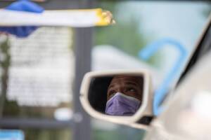  A man speaks with a doctor before getting tested for coronavirus at a COVID19 testing center. 