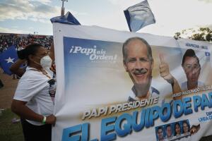 Una simpatizante del gobernante Partido Nacional con una pancarta del candidato presidencial Nasry Asfura, conocido como "Papi a la orden".