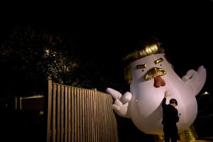 Un demócrata sostiene un muñeco inflable contra Trump en Fairfax, Virginia.