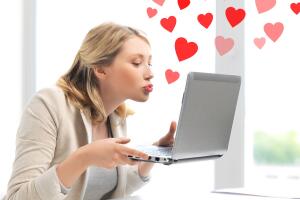 woman sending kisses with laptop computer