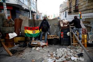 Demonstrators stand behind a barricade near Murillo square after Bolivia's Presidente Evo Morales announced his resignation on Sunday, in La Paz