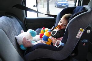 Toddler sitting in car seat.