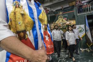 Varias personas portan una imagen de la Virgen de la Caridad del Cobre, patrona de Cuba, antes del oficio de una misa en el Watsco Center de Miami, Florida.