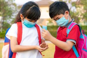 Asian boy student wear hygienic mask and press alcohol gel from 