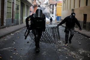 Riot police officers remove a fence used by demonstrators during protests after Ecuador's President Lenin Moreno's government ended four-decade-old fuel subsidies, in Quito