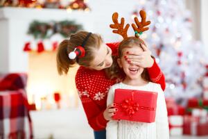 happy family mother and daughter giving christmas gift 