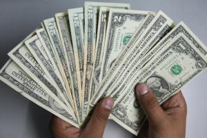 An Indian money changer poses as he coun