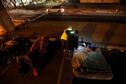 In this Monday, Jan. 28, 2019 photo, Brandi Gaines-Girard and Kip Berard, of Unity Outreach, talks to a man who identified himself as homeless, as they conduct a homeless census under the I-10 overpass on Claiborne Ave. in New Orleans. After years of a declining homeless population, agencies are “at a virtual standstill” as they struggle to keep up with the number of people newly homeless in the city, according to officials at Unity of Greater New Orleans. (AP Photo/Gerald Herbert)