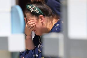 A woman mourns at a memorial with crosses and flowers for victims of the Uvalde school shooting Credit: Michael M. Santiago/Getty Images