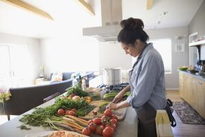 Latina woman cutting vegetables in kitchen