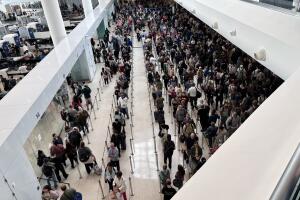 Pasajeros de aerolíneas hacen largas filas para pasar el control de seguridad de la TSA. 