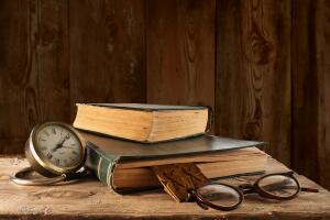 libros viejos con reloj y lentes