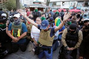 Members of the Youth Resistance "Cochala" group pray at Cala Cala square in Cochabamba