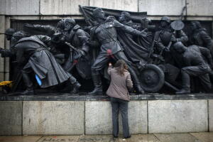 Member of Bulgarian Socialist Party's youth organisation cleans statue part of the Soviet Army monument in Sofia