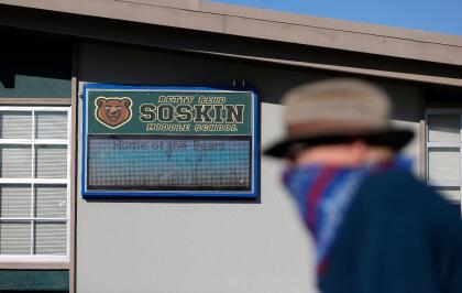 EL SOBRANTE, CALIFORNIA - SEPTEMBER 22: A pedestrian walks by a new sign that is displayed during a ceremony for the newly renamed Betty Reid Soskin Middle School on September 22, 2021 in El Sobrante, California. Soskin had the school renamed after her on her 100th birthday. She currently works at the Rosie the Riveter/World War II Home Front National Historical Park where she leads tours, speaks to groups and answers questions about living and working in the area during World War Two. Soskin worked as a clerk for the Boilermakers A-36 in Richmond, California during the war. (Photo by Justin Sullivan/Getty Images)