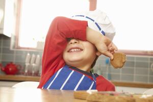 Young boy eating cookie in kitchen