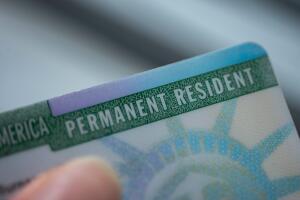 Close up view of Permanent resident card (Green) card of USA on blurred background. 