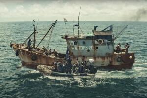 Embarcación oxidada Victory205 en el mar con lanchas rápidas