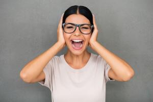 Mujer gritando y tapandose oidos