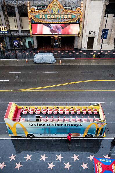 Está visual aérea muestra a un autobús de turistas completamente vacío y la entrada el famoso teatro El Capitán, bloqueada. Todo por la medida del distanciamiento social, "Más seguros en casa" que limita a las personas a salir solo por comida, medicinas y aquellos empleos esenciales. <br>