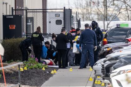 INDIANAPOLIS, IN - APRIL 16: (EDITORS NOTE: Image depicts death) A group of crime scene investigators gather around a body in the parking lot of a FedEx SmartPost on April 16, 2021 in Indianapolis, Indiana. The area is the scene of a mass shooting at FedEx Ground Facility that left at least eight people dead and five wounded on the evening of April 15. (Photo by Jon Cherry/Getty Images)