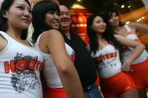 Hooters waitresses pose with customers a