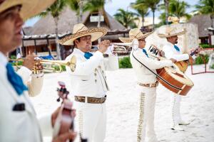 Traditional mexican music band playing trumpet and classical guitar for the beach wedding