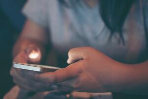 Midsection Of Woman Using Phone In Darkroom