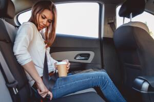 Young woman fastens a seat belt