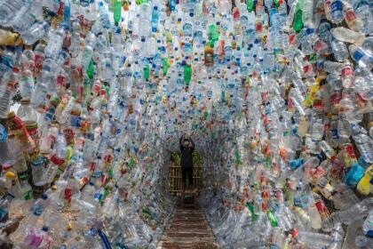 An Indonesian activist from ECOTON (ecological observation and wetland conservation) prepares an installation made with used plastic, including 4,444 bottles, collected from the river in Gresik on September 17, 2021, to raise public awareness of plastic waste in rivers and oceans. (Photo by JUNI KRISWANTO / AFP) (Photo by JUNI KRISWANTO/AFP via Getty Images)