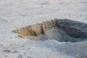 Dry sand land with a big dug hole close up