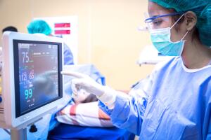 Female surgeon using monitor in operating room.