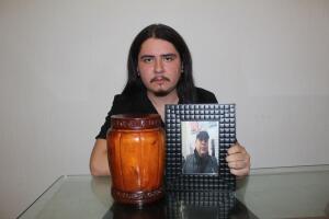 Rafael Hernández muestra una foto de su padre y la urna en la que están sus cenizas.