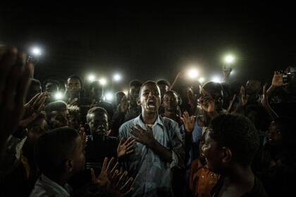 <b>Bajo las luces (de los teléfonos). </b>Durante un apagón, un joven iluminado por teléfonos móviles recita un poema mientras otros manifestantes gritan consignas pidiendo un gobierno civil, en Jartum, Sudán. La fotografía, tomada en junio de 2019 fue nominada en la categoría ‘noticias’.