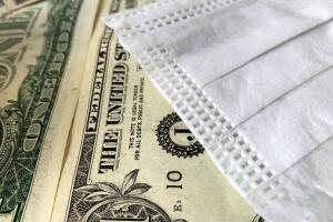 Concept of economic impact of the covid-19 pandemic: dollar  and surgical  mask