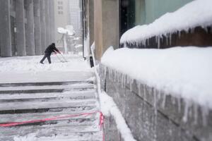 Un hombre despeja un paso peatonal en el bajo Manhattan durante la tormenta invernal. 