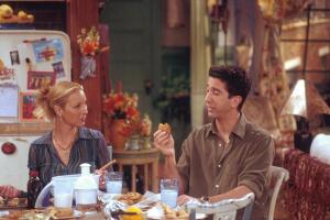 Phoeb y Ross, personajes de friends, comen en la mesa de un departamento.